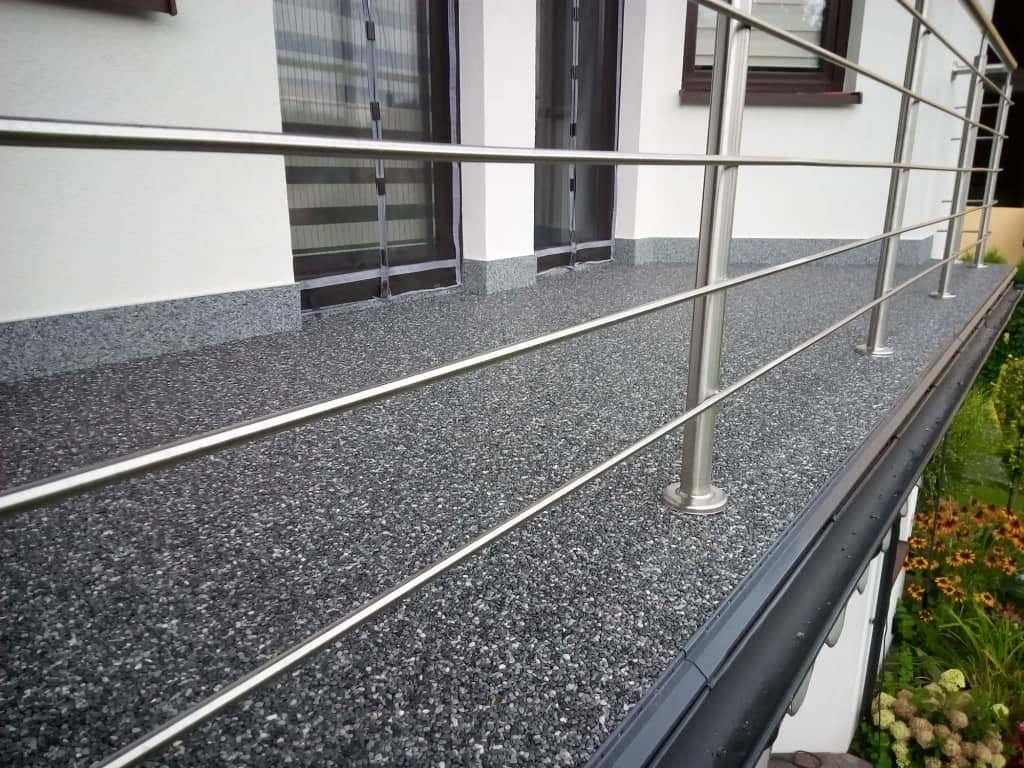 Grafitowy kamienny dywan na balkonie ze stalową balustradą