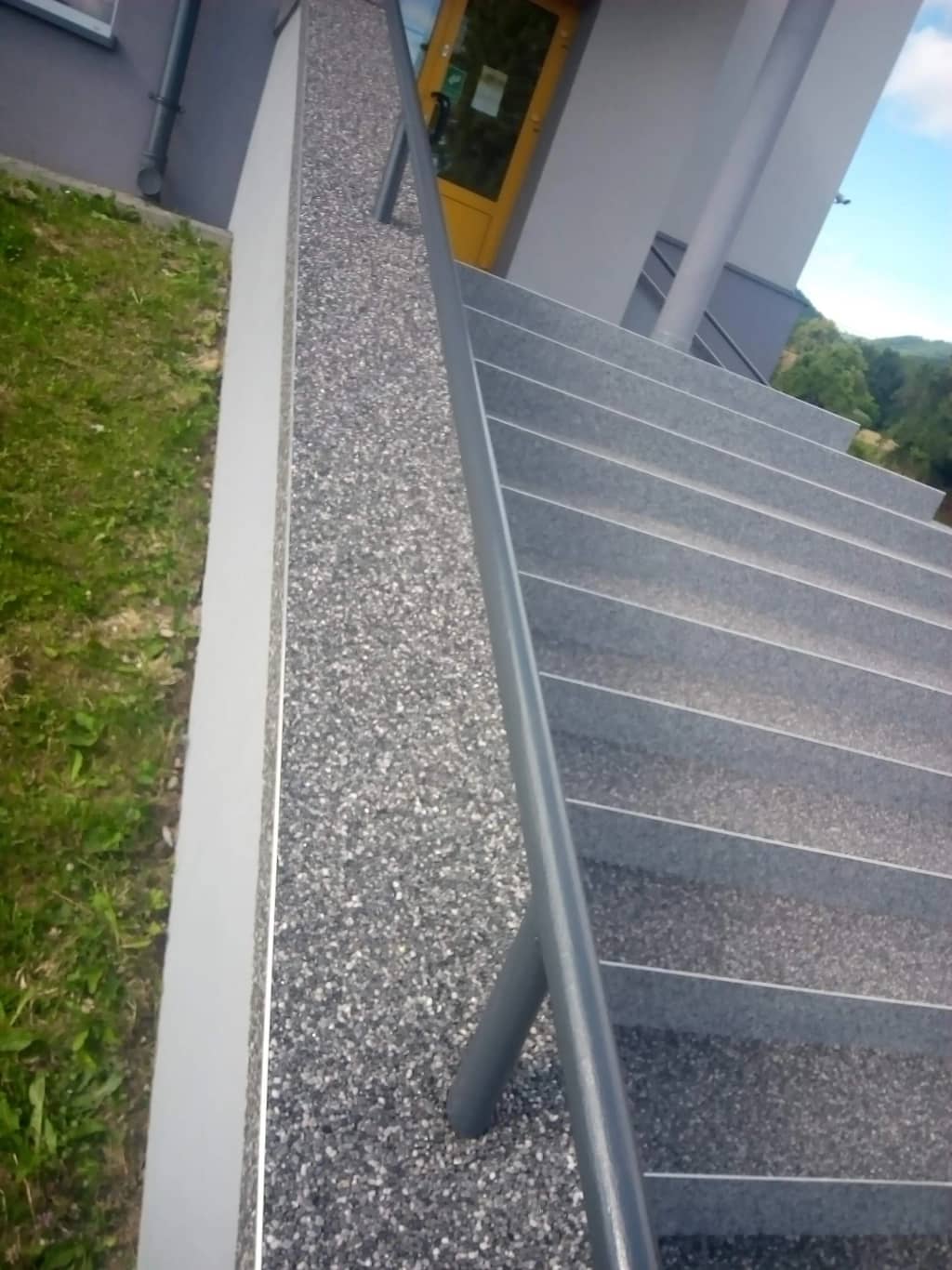 Kamienny dywan na schodach z powłoką wyprowadzoną na cokół przy ścianie