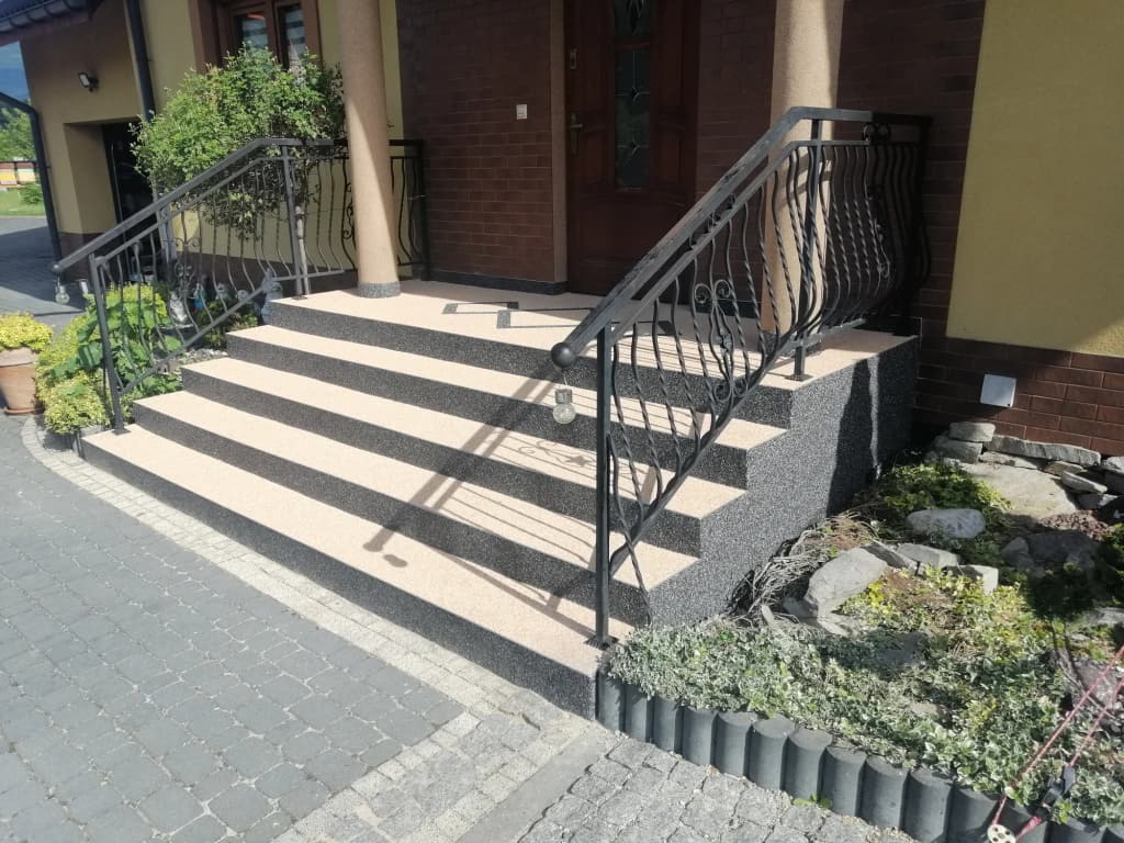 Kamienny dywan beżowo-grafitowy na schodach przed wejściem do domu