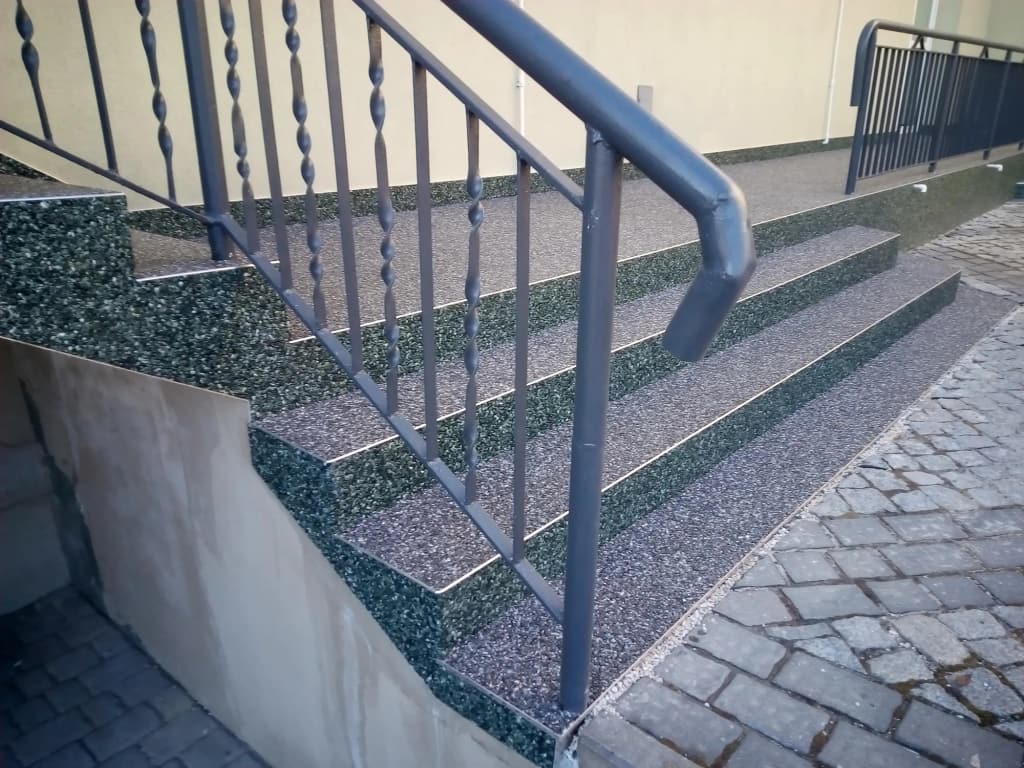 Kamienny dywan na biegu schodów zewnętrznych z pochwytem