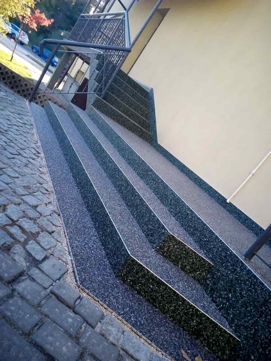 Kamienny dywan na stopniach połączonych z rampą dla wózków