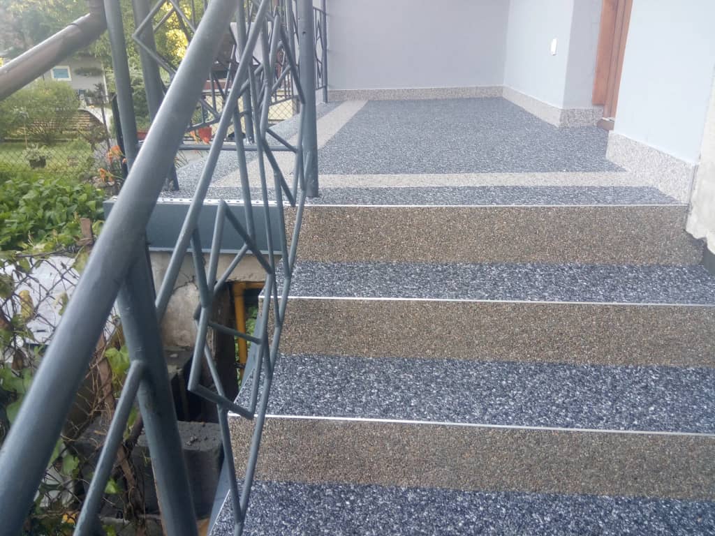 Kamienny dywan w odcieniach szarości na schodach wejściowych do domu
