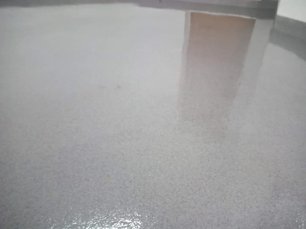 Zbliżenie na szarą posadzkę epoksydową z drobną posypką kwarcową
