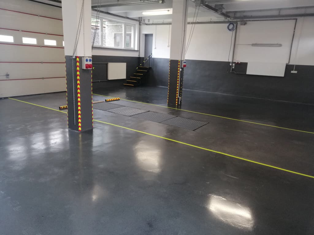 Grafitowa posadzka przemysłowa wokół podnośników samochodowych i kanału serwisowego