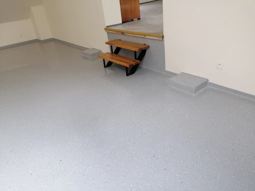 Szara posadzka żywiczna z płatkami przy drewnianym podeście
